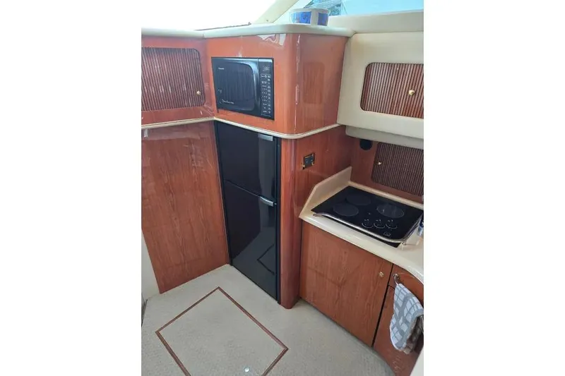  Yacht Photos Pics Interior of 2000 Sea Ray 400 Sedan Bridge yacht kitchen with wood cabinetry.