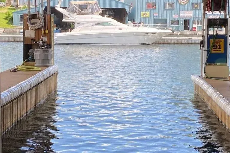  Yacht Photos Pics 2000 Sea Ray 400 Sedan Bridge yacht docked at marina with blue building background.