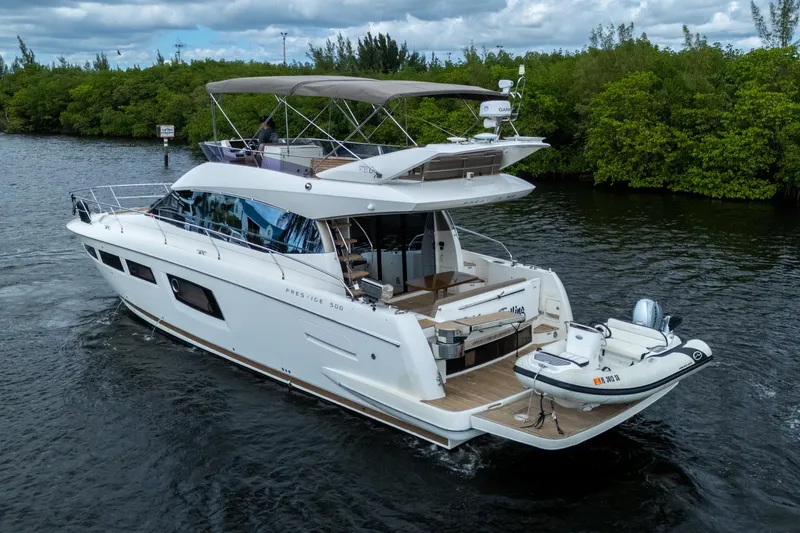  Yacht Photos Pics 2012 Prestige Flybridge yacht cruising on a scenic waterway with lush greenery.