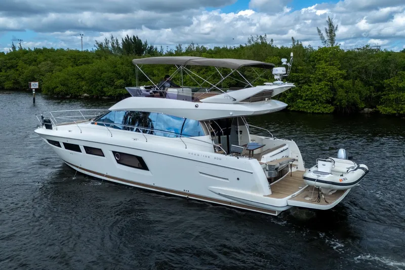  Yacht Photos Pics 2012 Prestige Flybridge yacht cruising on a scenic waterway with lush greenery.