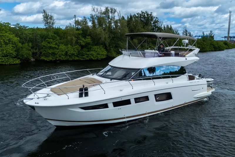  Yacht Photos Pics 2012 Prestige Flybridge yacht cruising on a scenic waterway with lush greenery.