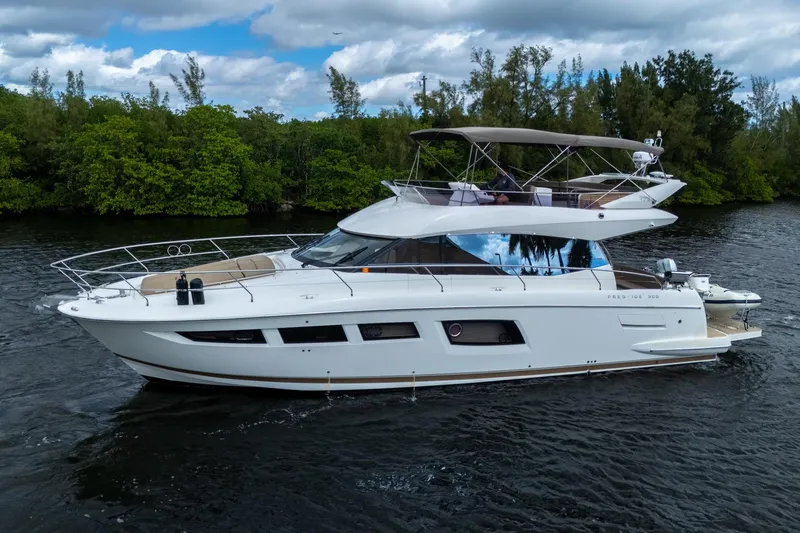  Yacht Photos Pics 2012 Prestige Flybridge yacht cruising on a serene river with lush greenery.