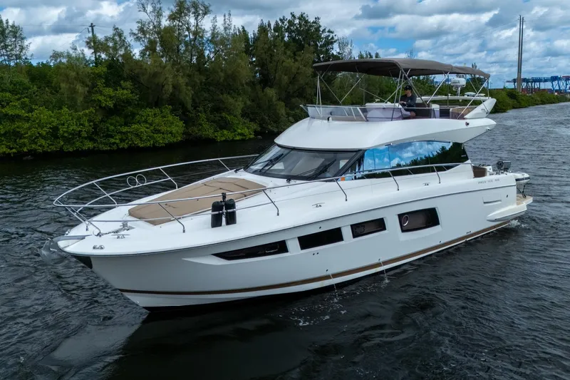  Yacht Photos Pics 2012 Prestige Flybridge yacht cruising on a scenic waterway with lush greenery.