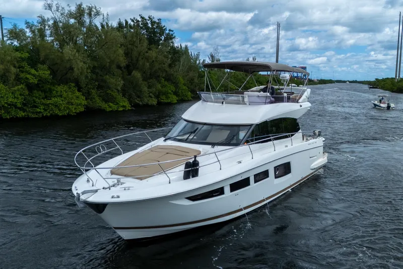  Yacht Photos Pics 2012 Prestige Flybridge yacht cruising on a scenic waterway with lush greenery.