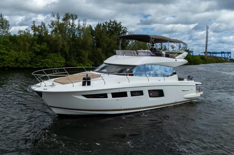  Yacht Photos Pics 2012 Prestige Flybridge yacht cruising on a scenic waterway under cloudy skies.