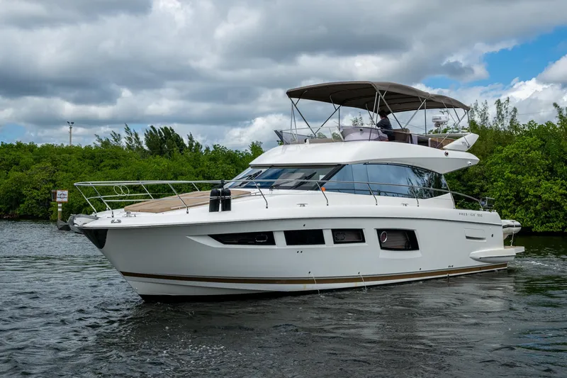  Yacht Photos Pics 2012 Prestige Flybridge yacht cruising on a scenic waterway under cloudy skies.