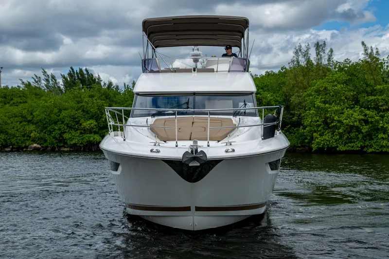  Yacht Photos Pics 2012 Prestige Flybridge yacht cruising on a scenic waterway with lush greenery.