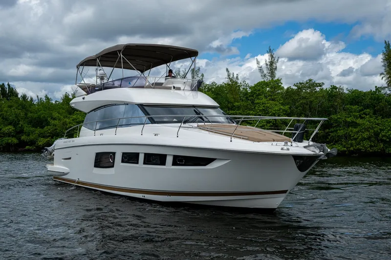  Yacht Photos Pics 2012 Prestige Flybridge yacht cruising on a scenic waterway under cloudy skies.