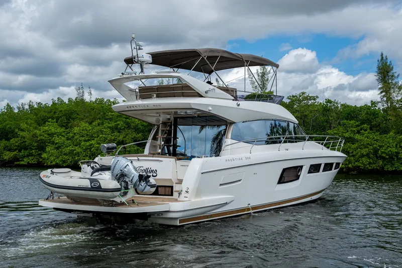  Yacht Photos Pics 2012 Prestige Flybridge yacht cruising on a scenic waterway with lush greenery.