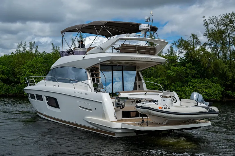  Yacht Photos Pics 2012 Prestige Flybridge yacht cruising on a scenic waterway with lush greenery.