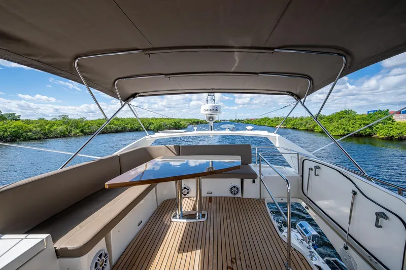  Yacht Photos Pics 2012 Prestige Flybridge yacht with spacious deck, elegant seating, and scenic waterway view.