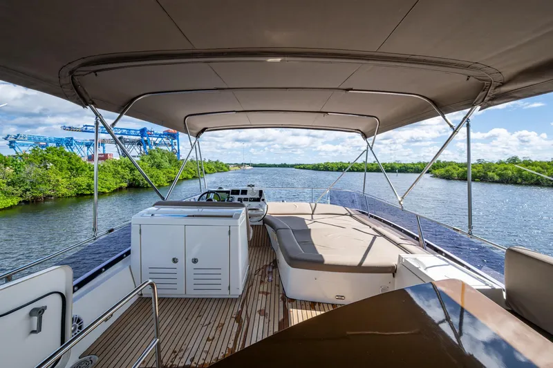  Yacht Photos Pics 2012 Prestige Flybridge yacht with spacious deck, canopy, and scenic river view.