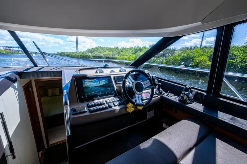  Yacht Photos Pics Interior view of 2012 Prestige Flybridge yacht cockpit with steering wheel and navigation system.