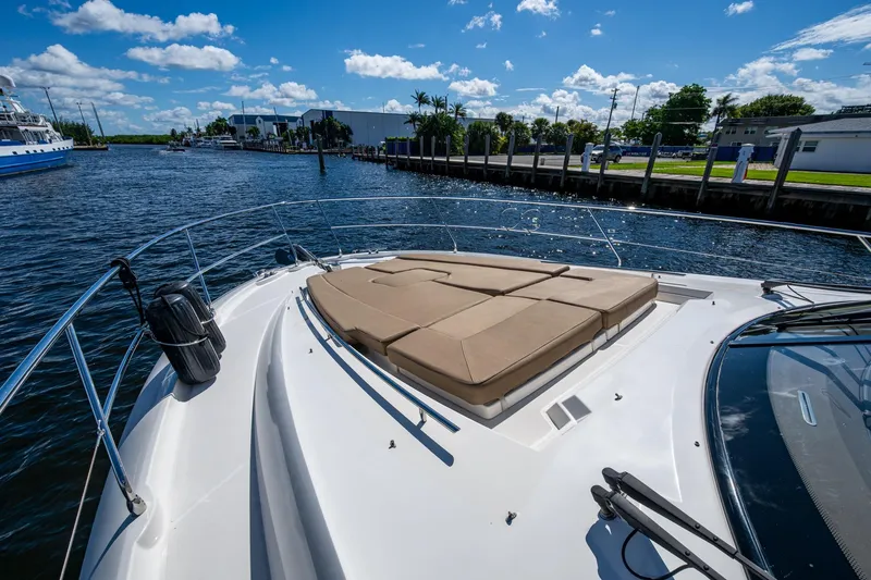  Yacht Photos Pics 2012 Prestige Flybridge yacht with sunbathing deck on a sunny day by the water.