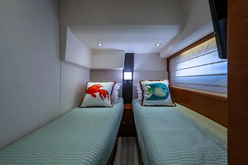  Yacht Photos Pics Twin beds in a 2012 Prestige Flybridge yacht cabin with decorative fish pillows.