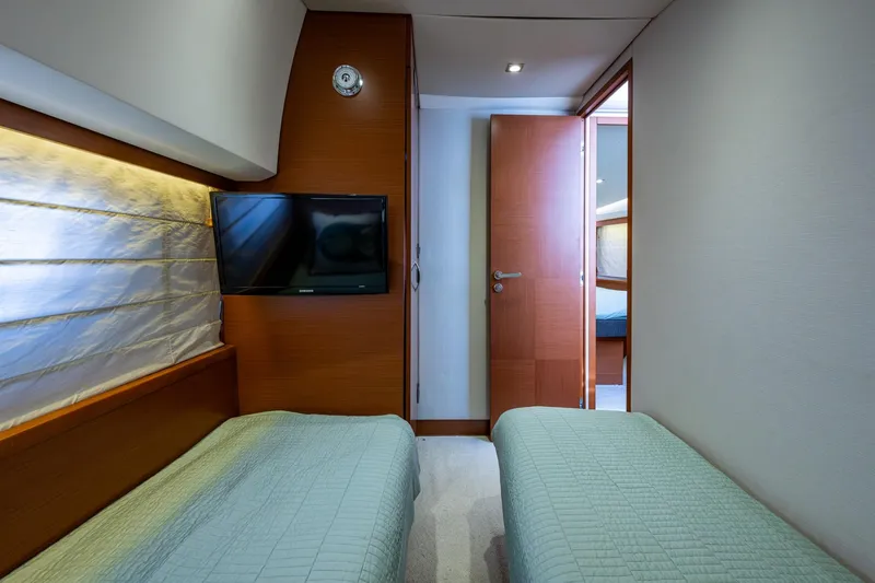  Yacht Photos Pics Interior of 2012 Prestige Flybridge yacht with twin beds and wall-mounted TV.