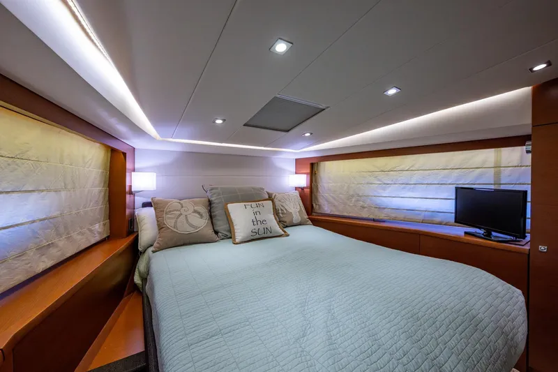  Yacht Photos Pics Luxurious bedroom interior of 2012 Prestige Flybridge yacht with cozy bedding and ambient lighting.