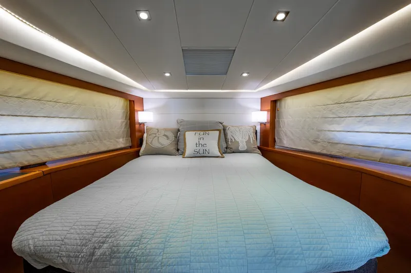  Yacht Photos Pics Luxurious bedroom interior of 2012 Prestige Flybridge yacht with cozy bedding and ambient lighting.