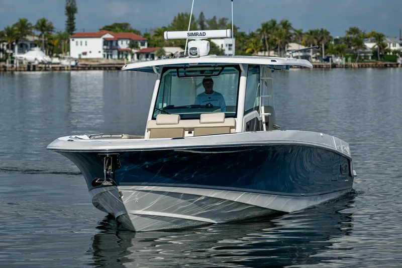  Yacht Photos Pics 2024 Boston Whaler 380 Outrage boat on calm water, showcasing sleek design and advanced features.