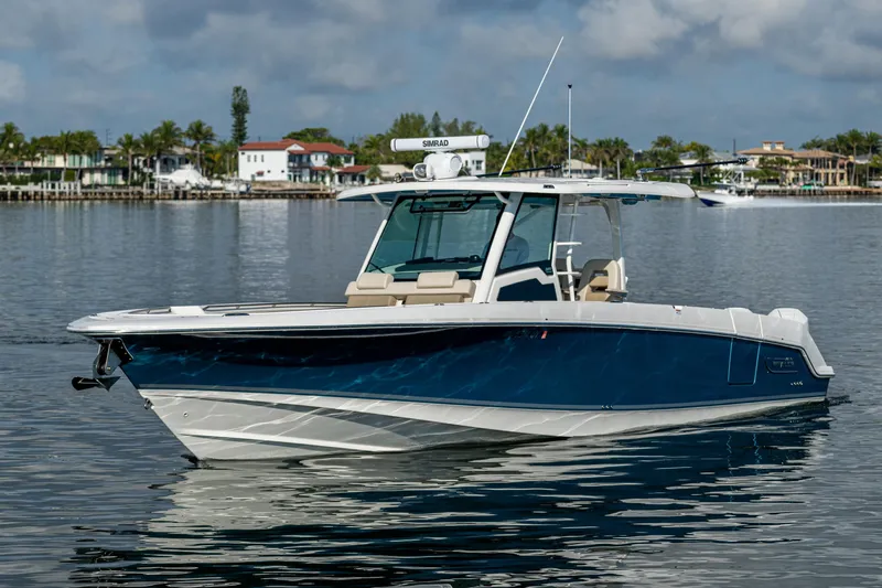  Yacht Photos Pics 2024 Boston Whaler 380 Outrage boat on calm water, showcasing sleek design and modern features.