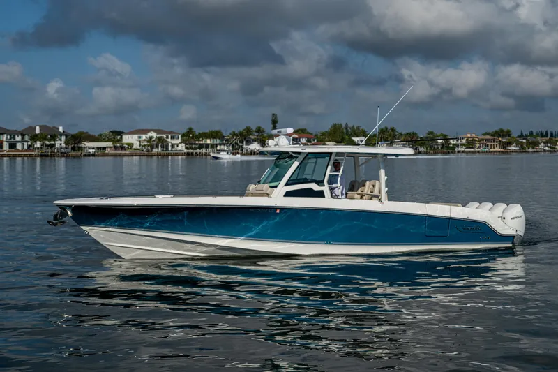  Yacht Photos Pics 2024 Boston Whaler 380 Outrage boat on calm water, showcasing sleek design and luxury features.