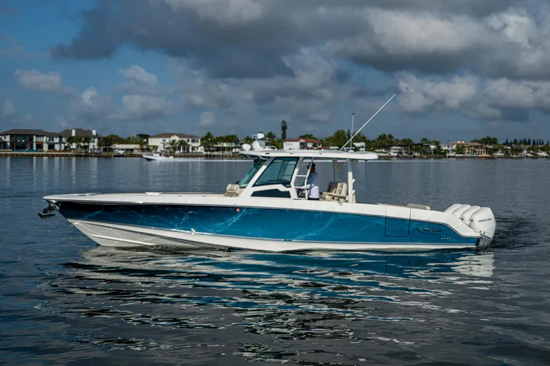  Yacht Photos Pics 2024 Boston Whaler 380 Outrage boat on calm water, under a cloudy sky.