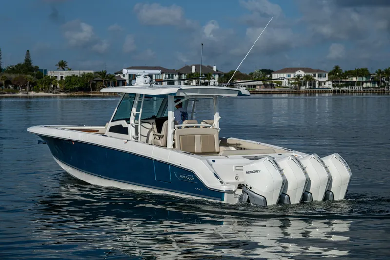  Yacht Photos Pics 2024 Boston Whaler 380 Outrage boat on calm water, showcasing sleek design and powerful engines.