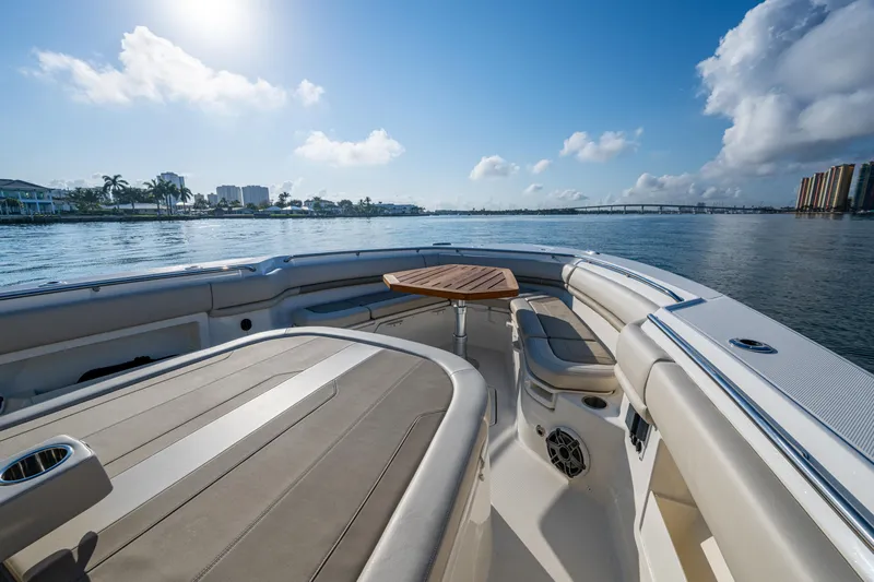  Yacht Photos Pics 2024 Boston Whaler 380 Outrage boat interior with seating and table, on a sunny day.