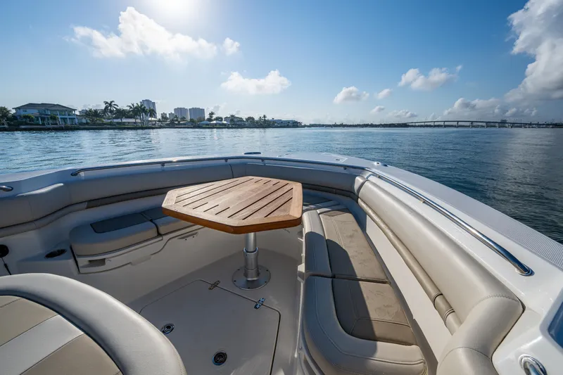  Yacht Photos Pics 2024 Boston Whaler 380 Outrage boat interior with seating and table on calm water.