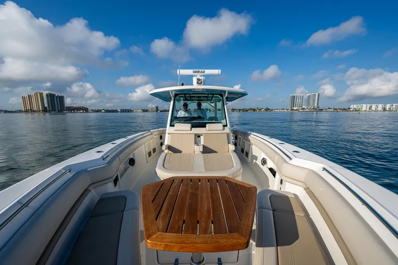  Yacht Photos Pics 2024 Boston Whaler 380 Outrage on calm water, showcasing spacious deck and seating.