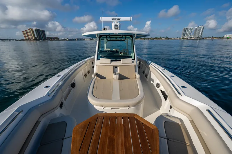  Yacht Photos Pics 2024 Boston Whaler 380 Outrage boat on calm water, featuring spacious deck and seating.