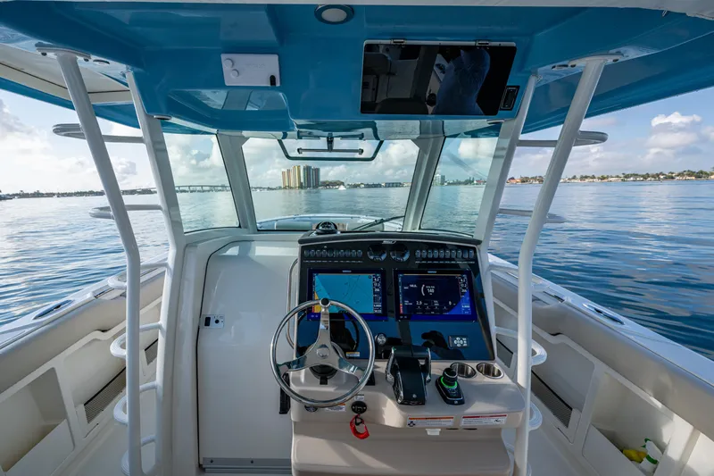  Yacht Photos Pics 2024 Boston Whaler 380 Outrage helm with advanced navigation systems on calm waters.