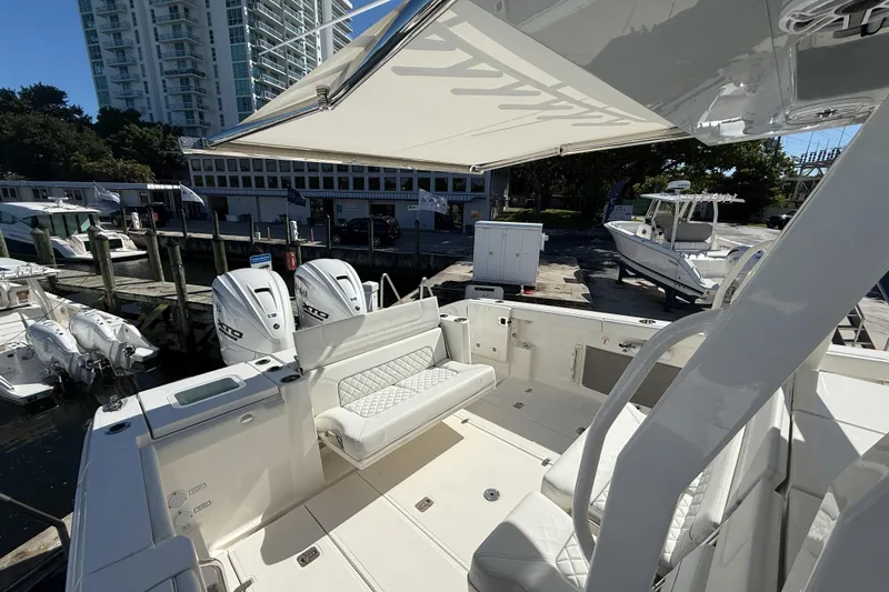  Yacht Photos Pics 2025 Pursuit S 358 Sport boat interior with seating, docked near other boats.