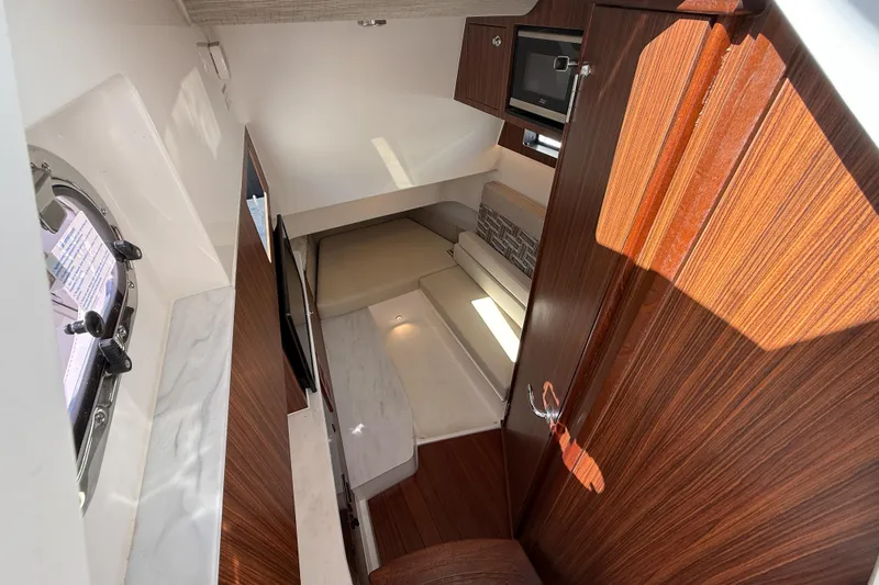  Yacht Photos Pics Interior of 2025 Pursuit S 358 Sport boat, featuring wood finishes and compact seating area.