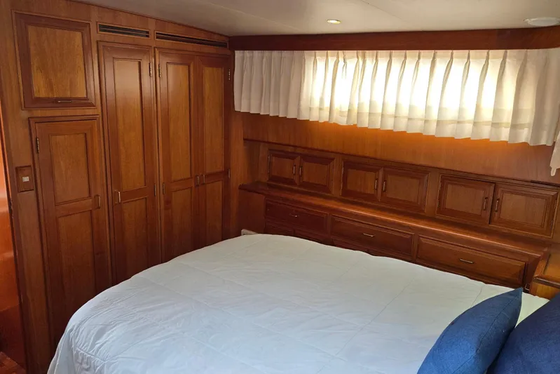 Laissez Faire Yacht Photos Pics Luxurious 1993 Ocean Alexander 423 Classicco yacht bedroom with wooden cabinetry and cozy bedding.