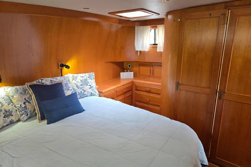 Laissez Faire Yacht Photos Pics Cozy bedroom in 1993 Ocean Alexander 423 Classicco yacht with wooden interior and plush bedding.