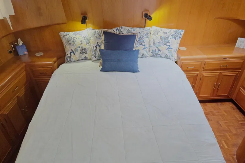 Laissez Faire Yacht Photos Pics Cozy bedroom in 1993 Ocean Alexander 423 Classicco yacht with floral pillows and wooden cabinetry.