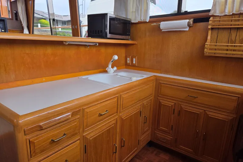 Laissez Faire Yacht Photos Pics 1993 Ocean Alexander 423 Classicco yacht kitchen with wooden cabinets and countertop.