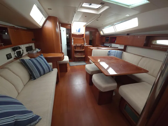 Surprise Yacht Photos Pics Spacious interior of 2007 Beneteau 49 yacht with elegant wood finish and comfortable seating.