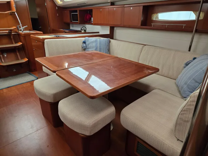 Surprise Yacht Photos Pics Interior of 2007 Beneteau 49 yacht with cozy dining area and wooden furnishings.