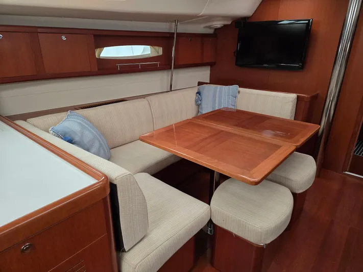 Surprise Yacht Photos Pics Interior of 2007 Beneteau 49 yacht with cozy seating and wooden table.