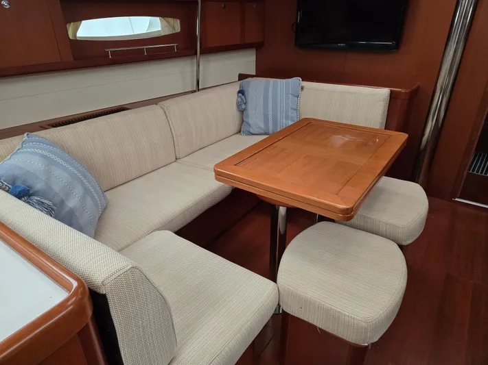 Surprise Yacht Photos Pics Interior of 2007 Beneteau 49 yacht with cozy seating and wooden table.