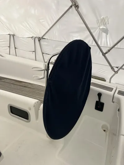 Surprise Yacht Photos Pics 2007 Beneteau 49 sailboat cockpit with covered steering wheel, white interior, and protective canopy.