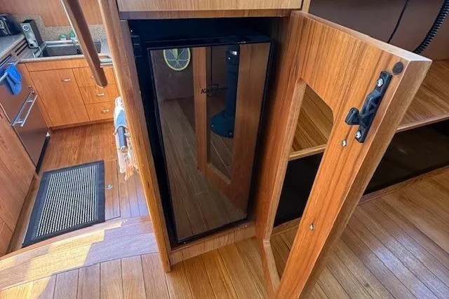 Jesse James Yacht Photos Pics Interior of 2011 Tiara Yachts 5800 Sovran with wooden cabinetry and compact fridge.