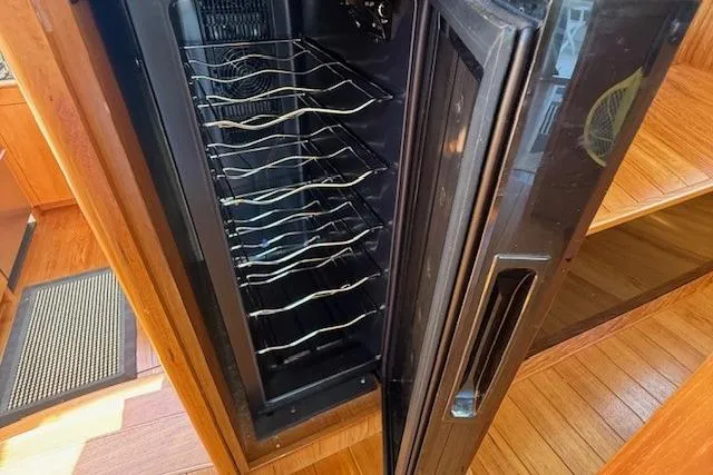 Jesse James Yacht Photos Pics Wine cooler inside 2011 Tiara Yachts 5800 Sovran, featuring wooden interior flooring.