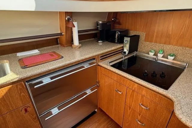 Jesse James Yacht Photos Pics Modern kitchen in 2011 Tiara Yachts 5800 Sovran with stove, fridge, and wood cabinetry.