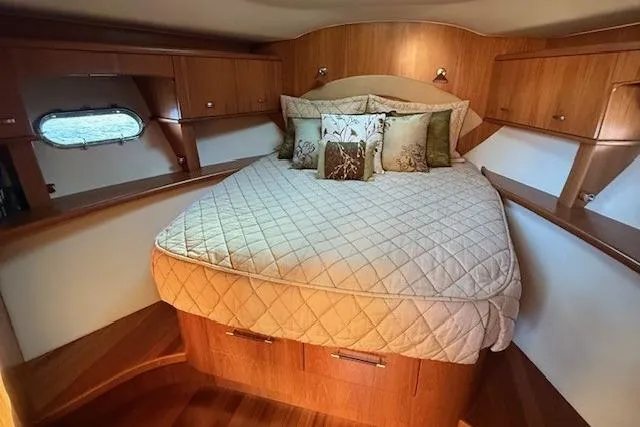 Jesse James Yacht Photos Pics Luxurious bedroom interior of 2011 Tiara Yachts 5800 Sovran with elegant bedding and wood finish.