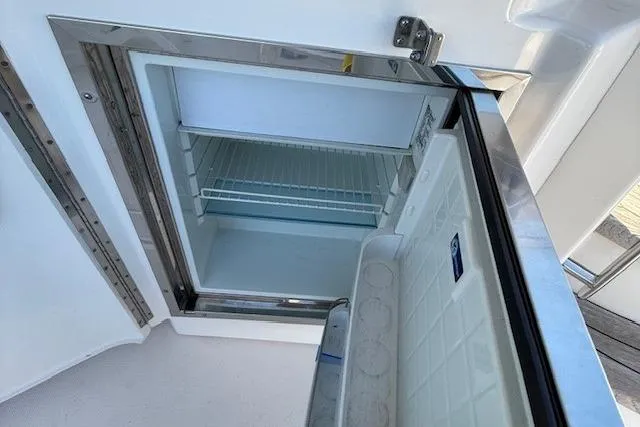 Jesse James Yacht Photos Pics Open refrigerator on 2011 Tiara Yachts 5800 Sovran, showcasing interior storage space.