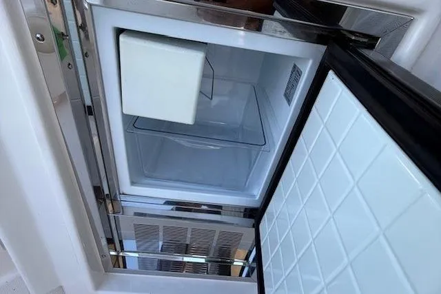 Jesse James Yacht Photos Pics Open refrigerator on 2011 Tiara Yachts 5800 Sovran, showcasing interior storage space.