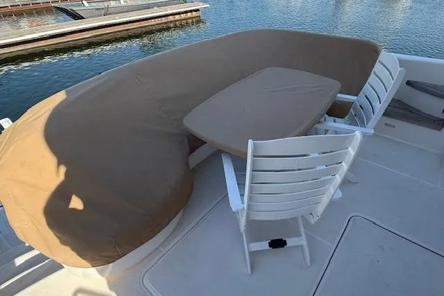 Jesse James Yacht Photos Pics Outdoor seating area on 2011 Tiara Yachts 5800 Sovran, featuring covered cushions and chairs.
